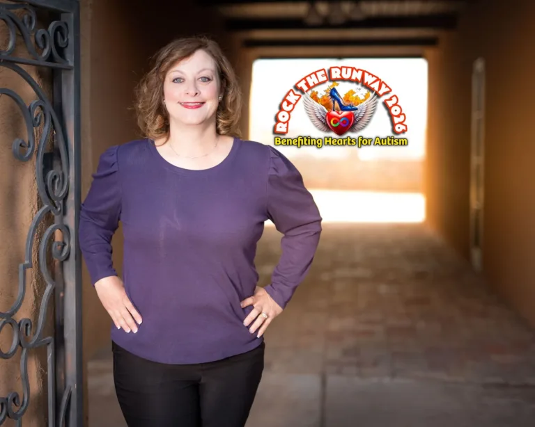 A smiling person in a purple shirt stands in a corridor with a "Rock the Runway" logo in the background.