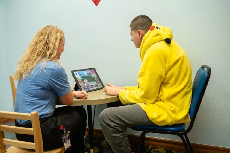 Terapeuta y niño usando una tableta en una sala de Terapia Esperanza.
