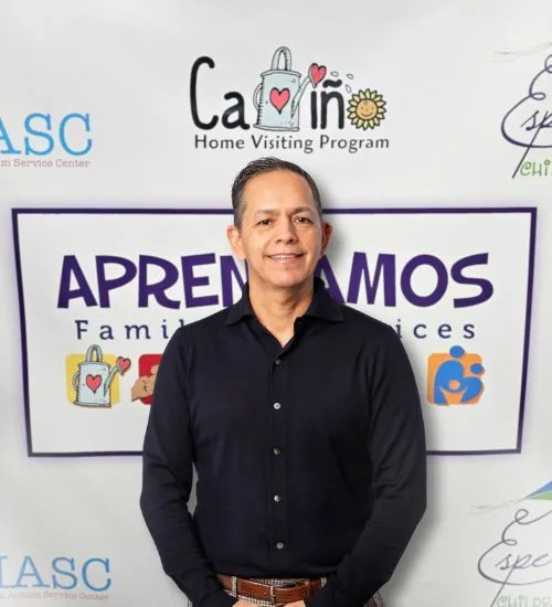Abel Covarrubias, CEO, standing in front of branded logos for the Aprendamos Family of Programs.