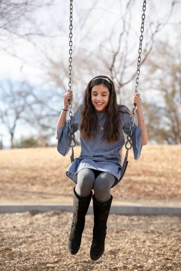Niña columpiándose en un parque infantil