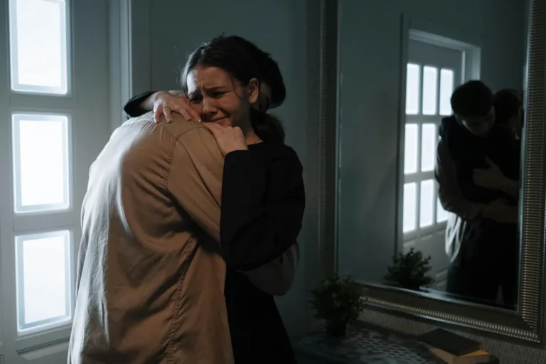 A person crying while being comforted in a quiet room.