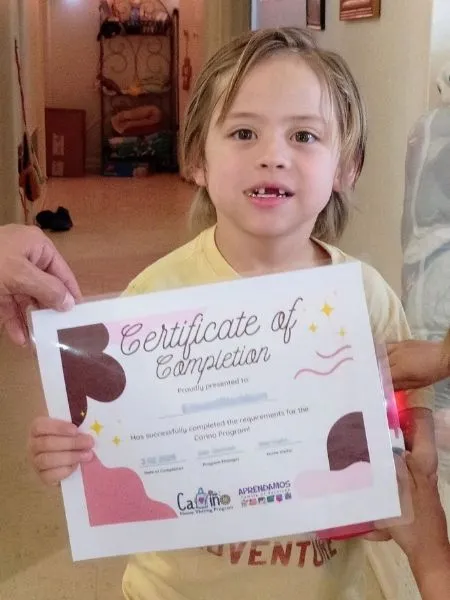 Niño sujetando un certificado de finalización