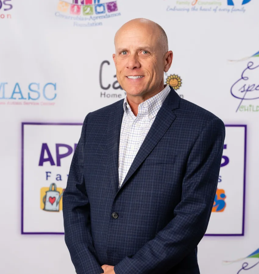 Danny Palma, founder of Direct Therapy Services, standing in front of a branded backdrop.