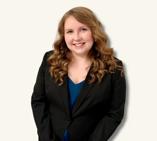 Portrait of Elisa McLaughlin in a black blazer over a blue top