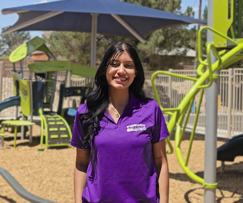A behavior technician smiles at the camera in the MASC playground.