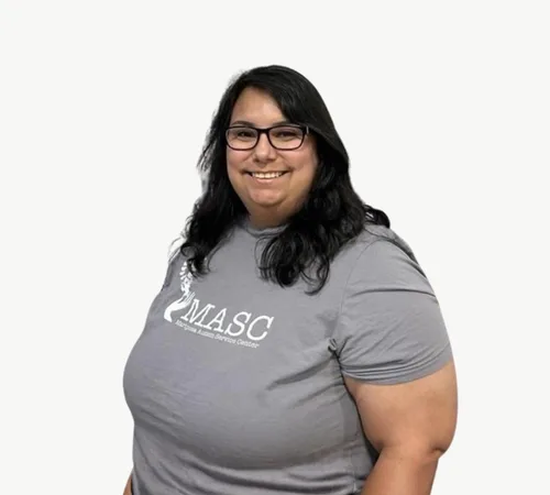 Gaby Rodriguez wearing glasses and a gray MASC T-shirt on a white background