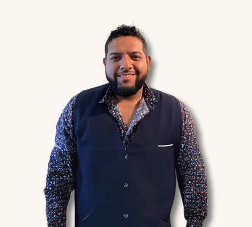 Portrait of Gamaliel Soto in a dark vest and patterned shirt against a white background