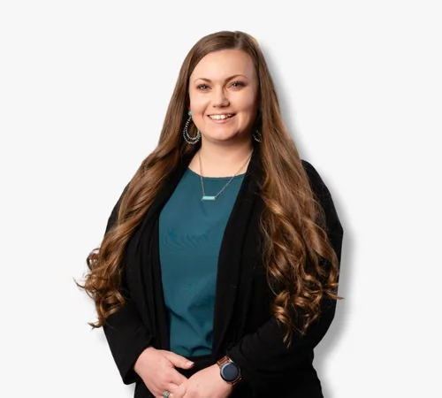 Portrait of Johnna Valdivia with long brown hair wearing a teal top and black cardigan on a white background