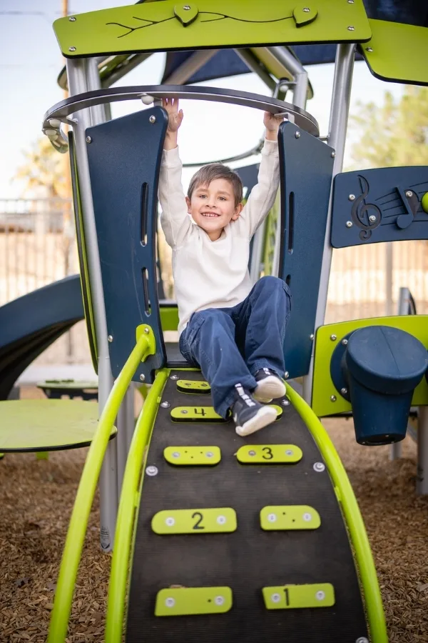 Boy smiling while climbing a playground structure