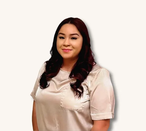 Paola Cabrera with long dark hair wearing a light satin blouse against a white background