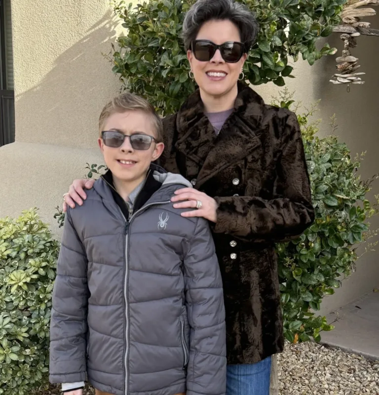 Camille Plante standing outdoors with her son Ryder smiling together.