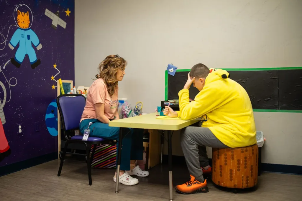A therapist supports a child through an SBT session at Mariposa Autism Service Center in Las Cruces.