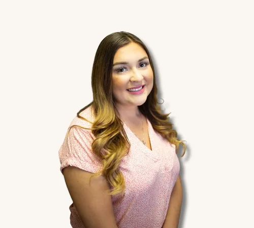 Samantha Gomez with long wavy hair wearing a pink blouse against a light background