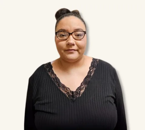 Portrait of Stephanie Giron wearing glasses and a black top against a light background