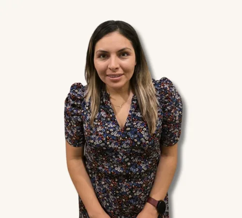 Yesenia Aldaba standing against a plain background, wearing a floral dress
